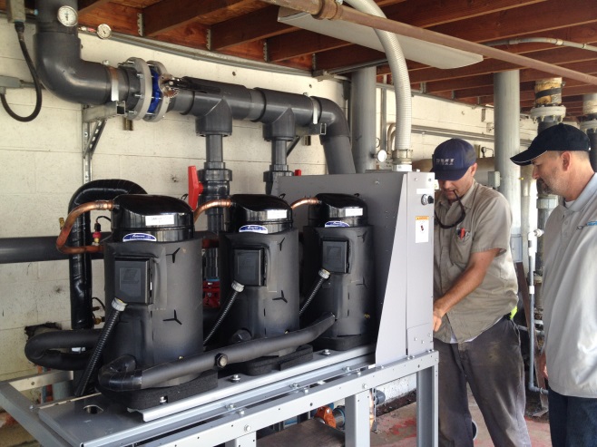 Men provide HVAC installation services for Ano-Tech Metal Finishing.